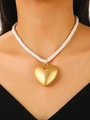 Collier avec pendentif cœur ajouré doré et cordon blanc tressé porté par un mannequin - Pendentif Coeur Doré (Cordon Blanc)