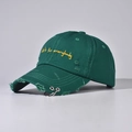 Dettaglio del cappello vintage con anelli metallici e ricamo giallo sulla parte frontale - Regolabile / Verde
