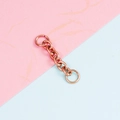 Primer plano de conector de cadena de metal bronce con anillas abiertas en fondo bicolor - Oro Rosa