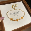 Dettaglio del bracciale placcato oro 18K con fiori di zircone arancione e chiusura - Stile Quadrifoglio Arancione Regolabile / Oro-Arancione