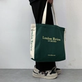 Green and cream canvas tote bag with London Review of Books print in hand-held view - Green