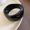 Detailed macro view of wide irregular black acrylic bangle with high-gloss glazed finish - Minimalist Glossy Black (Wide)