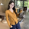 Détail d'un cardigan en maille jaune gingembre avec col en V et bordures à volants doux - S / Orange