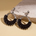 Detail of leather-wrapped hollow geometric circle earrings on a natural stone base - Coffee