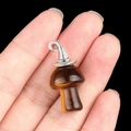Tiger's Eye mushroom pendant with silver wizard hat cap held in hand on black background - Gun Black Cap / Tiger's Eye