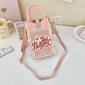 Detailed macro view of pink knit crossbody phone bag with red Holiday text and snap button - 13-Pink and White-Holiday