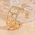 Detailweergave van de gouden opengewerkte bloemenarmband en bijpassende ring set - Gouden Bloem (Armring + Ring Set)