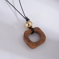 Detailed view of a brown resin square pendant necklace with golden beads and black cord - Brown