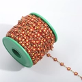 Detailed view of red and yellow daisy flower DIY chain on a green spool roll - Gold+Red
