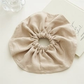 Detailed close-up of an oversized beige fabric scrunchie with soft textured finish - Beige
