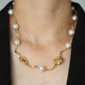 Dettaglio della collana a onde placcata oro 18k con perle bianche su modella in nero - DN240552-E Stile Patchwork di Perle