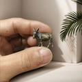 Primo piano di una statuina di asino in rame in miniatura tenuta per la scala - Asino Altezza 21mm