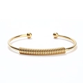 Detail of 18K gold-plated stainless steel open bangle with spring design and ball ends - Gold