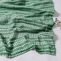 Soft dark green muslin baby blanket with white triangle patterns in natural folds - Dark Green White Triangle