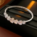 Détail du bracelet en argent avec zircons en cœur sur un coffret en cuir noir - Style Cœur / Argent