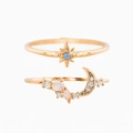 Detail view of gold rings with star and moon charms featuring zircon and pink gems - US 7 / Rose Gold