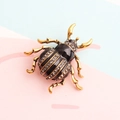 Elegant black enamel beetle brooch with gold-tone plating and sparkling rhinestones - Black