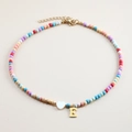 Close-up of colorful stone beaded necklace with white heart and gold letter E pendant - Letter E