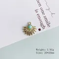 Detail view of a sunburst pendant with a blue bead center on a minimalist card background - 5# Gold Sunburst Green Stone
