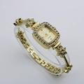 Detailed side view of luxury gold square watch with crystal bezel and floral bracelet - Gold Case Gold Dial