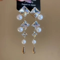 Dettaglio di orecchini pendenti con cristalli quadrati, perle bianche e pendenti dorati - Perno per orecchini in argento-Oro-Trasparente
