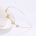 Elegant gold metal headband with pearl and rhinestone bow on a white teacup - Gold Butterfly Pearl