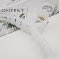 Detail of a large matte cream shark hair claw clip with golden spring on a minimalist background - Fruit White