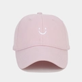 Detailed view of pink cotton twill baseball cap with white embroidered smiley face - Adjustable / Pink