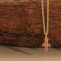 Gold cross necklace featuring six round ruby-red gemstones on a delicate link chain - Round Red Zirconia Cross