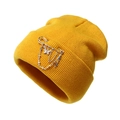 Detail of mustard yellow knit beanie with silver butterfly and cross chain pins - One Size / Yellow