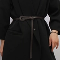 Ceinture fine en cuir marron foncé avec fermeture à nœud sur une veste noire - café