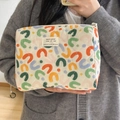 Dettaglio della borsa da trucco trapuntata con motivo a U e etichetta tessuta morbida - Pochette a Mano Colorata