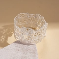 Macro view of silver matte cuff bracelet with intricate hollow floral mosaic pattern - Silver