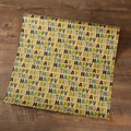 Papier cadeau kraft à motif Happy Birthday coloré disposé sur un fond en bois sombre - Lettre Verte