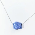 Detailed view of raw lapis lazuli stone pendant on a slim silver-tone chain necklace - Lapis Lazuli