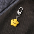 Cute yellow star keychain with a smiling face and silver metal clasp on dark background - Star (F523K)