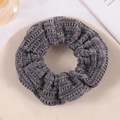 Detail showing grey knitted velvet scrunchie texture on a beige ceramic plate - Dark Gray