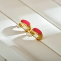 Orecchini geometrici dorati con finitura in smalto fucsia su scatola da esposizione - Rosso