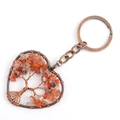 Macro detail of bronze tree of life heart keychain with natural red crystal stones - Red Agate