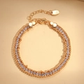 Detail of double-row gold chain bracelet with round white zircons and lobster clasp closure - Gold