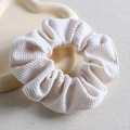 Close-up of white waffle texture scrunchie on a decorative cloud tray accessory - White