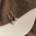 Macro detail of French vintage baroque pearl earrings with elegant gold twisted metal knot - Style 4