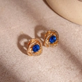 Detalle de pendientes en espiral dorados con piedra azul y detalles de diamante - Azul