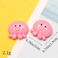 Detailed size view of two pink resin octopus charms on a yellow and blue background - Red Little Octopus