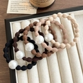 Five elastic hair ties with large faux pearls in neutral earth tones on a soft tray - Mixed Colors