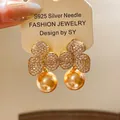 Orecchini a fiore placcati oro con perle champagne e perni in argento S925 - Orecchini - Oro (Perno in Argento Sterling 925)