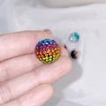 Rainbow gradient rhinestone clay bead held between fingers for DIY jewelry design - 16mm Rainbow Round Bead