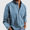 Primer plano de camisa vaquera de algodón azul con manga larga y bolsillo frontal - Azul cielo