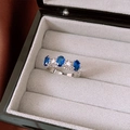 Detail of silver hollow ring with three oval blue gemstones and small white zircons - Oval Blue Zirconia Style