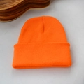 Gros plan détaillé du bonnet en maille orange vif avec une texture côtelée classique - Orange